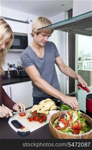 Man cooking with woman in kitchen