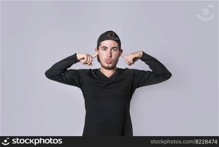 Man covering his ears isolated, guy covering his ears on isolated background, man with hands on his ears and making fun, man ignoring problems