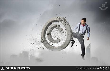 Man crashing copyrighting sign. Determined businessman breaking stone copyrighting sign with hand punch