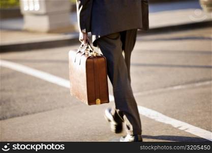 Man crossing the street holding a briefcase, Washington DC, USA