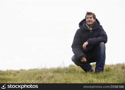 Man Crouching In Park