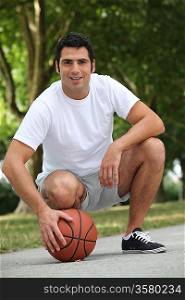 Man crouching with basket ball