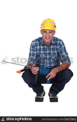 Man crouching with drill