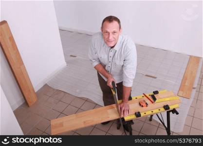 Man cutting a wooden plank
