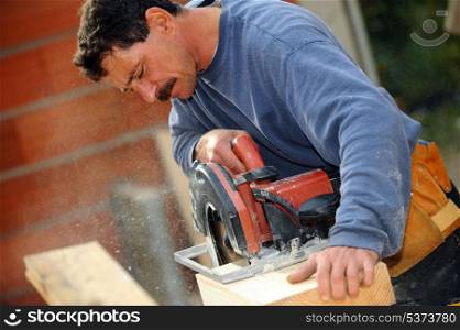 Man cutting block of wood to size using circular saw