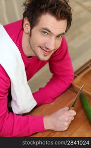 Man cutting cucumber on the countertop