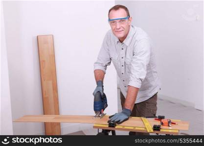 Man cutting floorboard