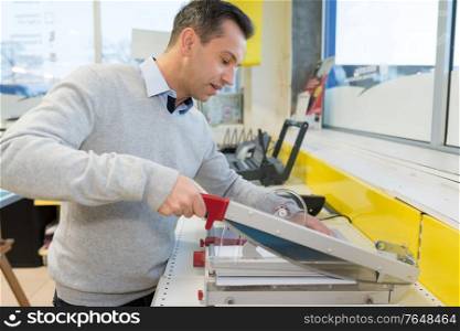 man cutting print with precision machine