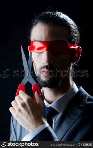 Man cutting ribbon on his eyes