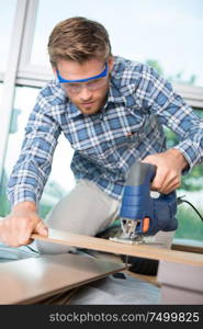 man cutting wooden board