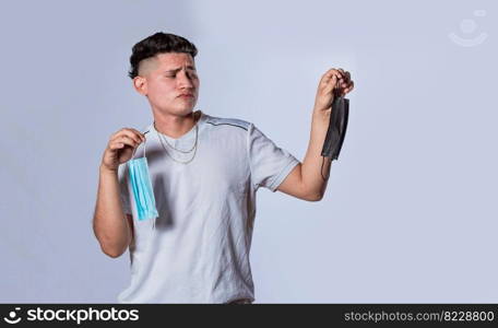 Man deciding to wear surgical mask, Latin man deciding to wear surgical mask on isolated background
