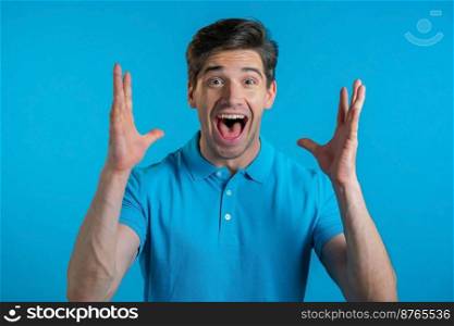 Man depicts amazement, shows WOW delight face effect. Surprised excited happy guy. Handsome male shocked model on blue background. Man depicts amazement, shows WOW delight face effect. Surprised excited happy guy. Handsome male shocked model on blue background.