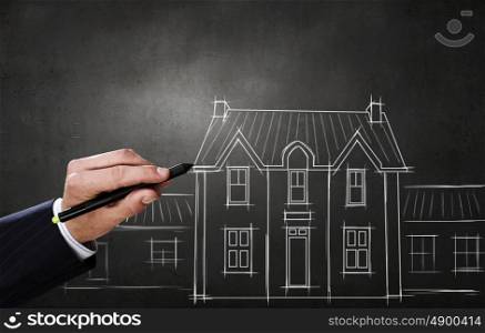 Man designing construction concept. Close up of hand drawing construction project on chalkboard