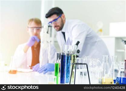 Man doctor as male scientist team doing some research working conduct experiments in modern laboratory / Scientists in lab biochemistry genetics forensics microbiology and test tube
