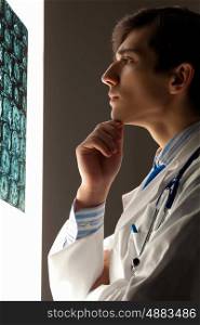 Man doctor looking at x-ray. Image of male doctor looking at x-ray results