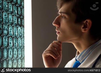 Man doctor looking at x-ray. Image of male doctor looking at x-ray results