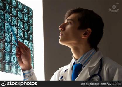 Man doctor looking at x-ray. Image of male doctor pointing at x-ray results