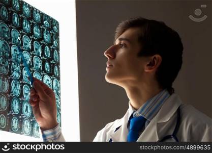 Man doctor looking at x-ray. Image of male doctor pointing at x-ray results