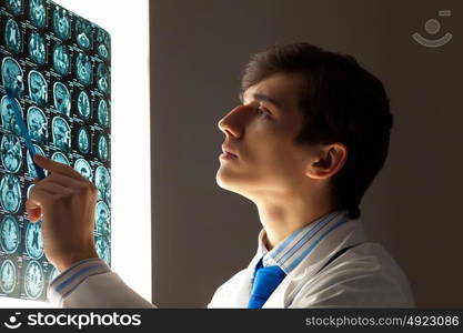 Man doctor looking at x-ray. Image of male doctor pointing at x-ray results