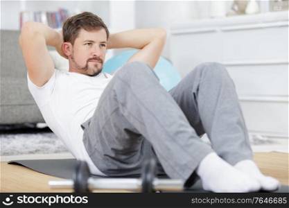 man doing ab training and crunches in living room gym
