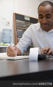 Man doing accounts in cafe