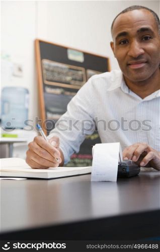 Man doing accounts in cafe