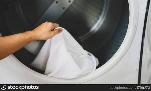 Man doing launder holding basket with dirty laundry of the washing machine in the public store. laundry clothes