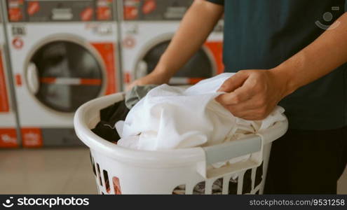 Man doing launder holding basket with dirty laundry of the washing machine in the public store. laundry clothes 