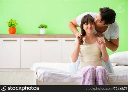 Man doing massage to his wife in bedroom 
