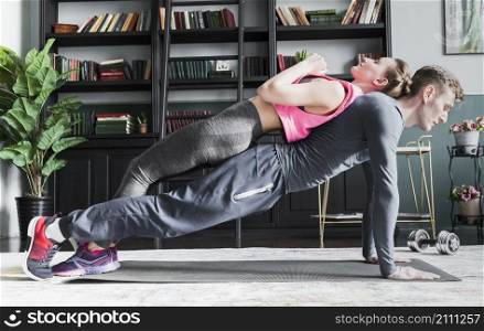 man doing push ups with woman spine