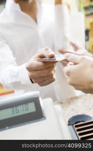 man doing shopping in a grocery store and paying by credit card