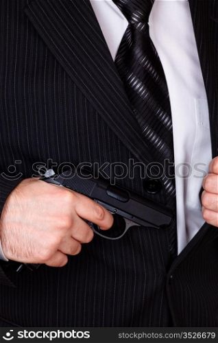 man drawing his gun from jacket pocket closeup