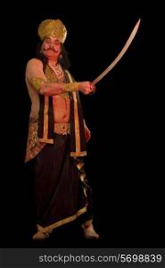 Man dressed as Raavan holding a sword