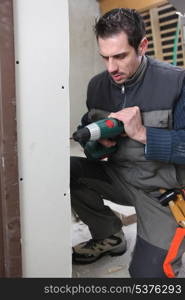 Man drilling an interior wall