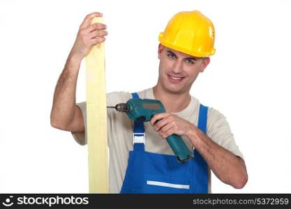 Man drilling hole into wooden plank