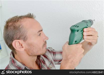 Man drilling into wall