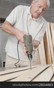 Man drilling on a wooden board
