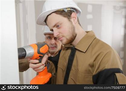 man drilling the wall with drill