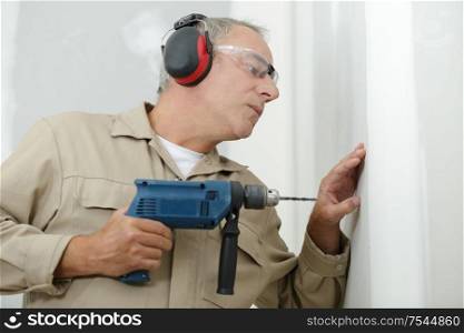 man drilling the wall with drill perforator