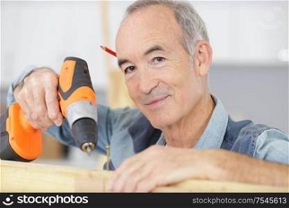 man drilling wood with battery power drill