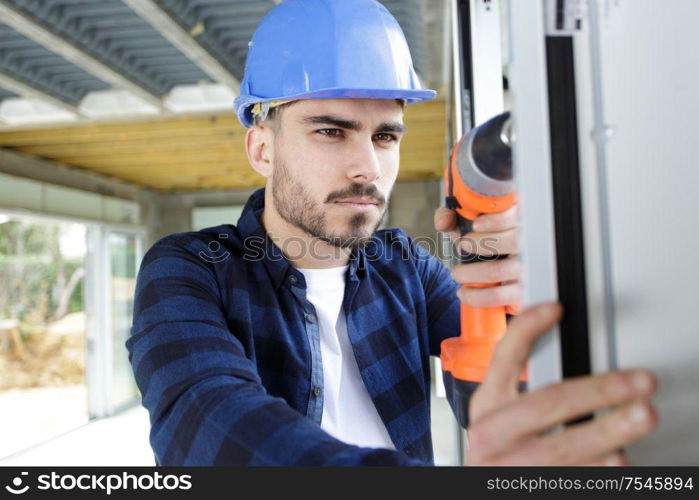 man drills a plastic window