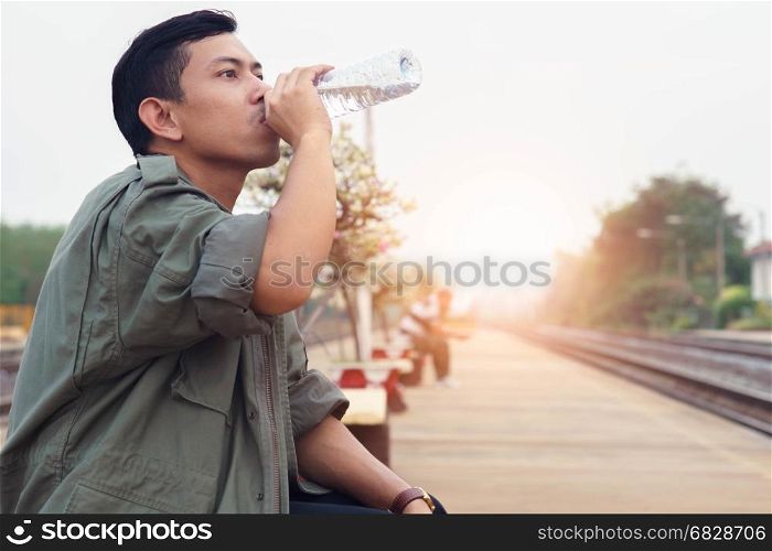 Man drink water while waiting for the trip.