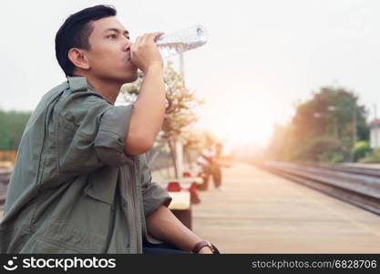 Man drink water while waiting for the trip.