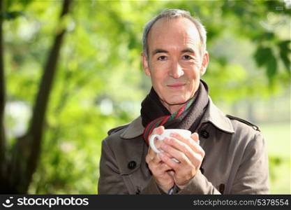 Man drinking a hot drink outdoors