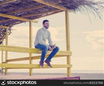 Man Drinking Beer on beach during autumn time. man drinking beer at the beach