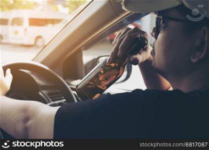 Man drinking beer while driving a car