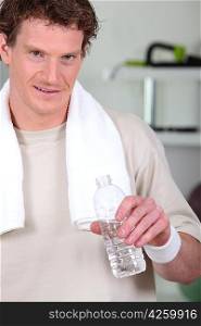 Man drinking bottled water in gym