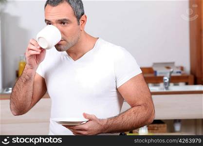Man drinking coffee in kitchen