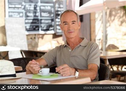 Man drinking coffee outside a cafe