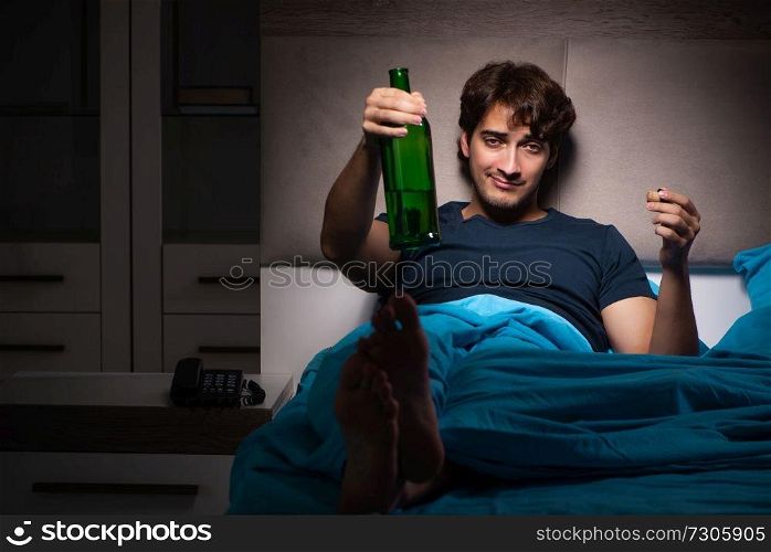 Man drinking in the bed under stress